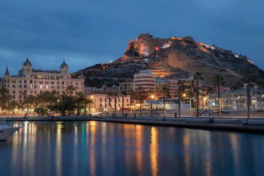 Castillo de Santa Bárbara y puerto de Alicante iluminados al anochecer